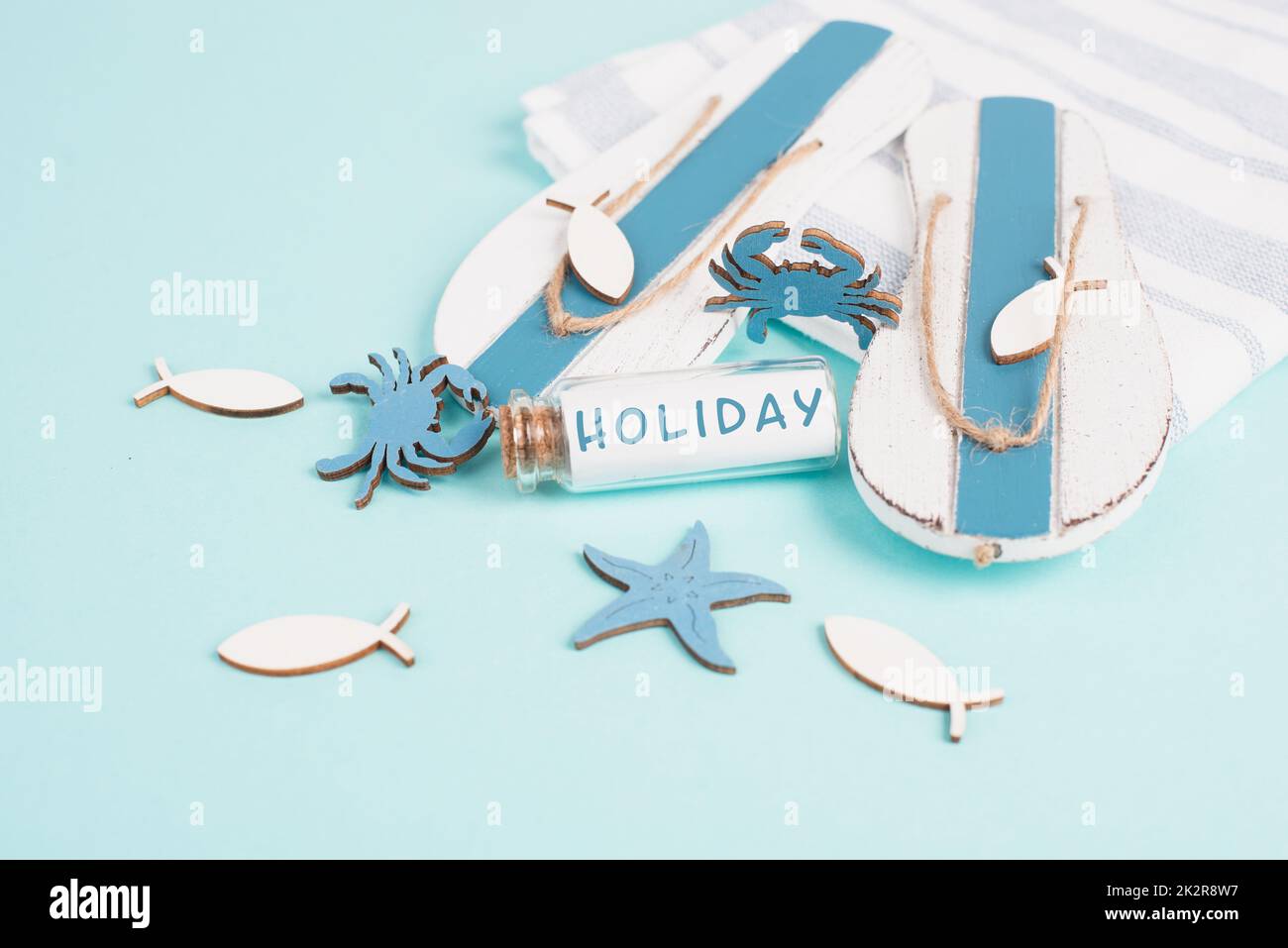 Blue colored summer and vacation background, flippers, sea stars and a glass bootle with the word holiday, travel and tourism concept Stock Photo