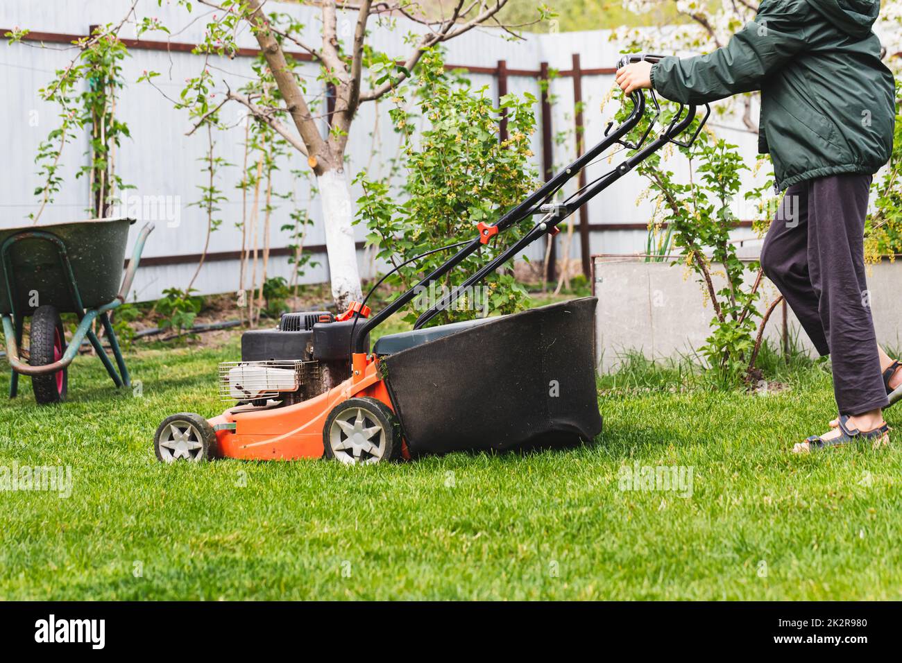 Lawn mover on green grass in sunny day. Lawn mover on green grass in modern garden. Machine for cutting lawns. Stock Photo