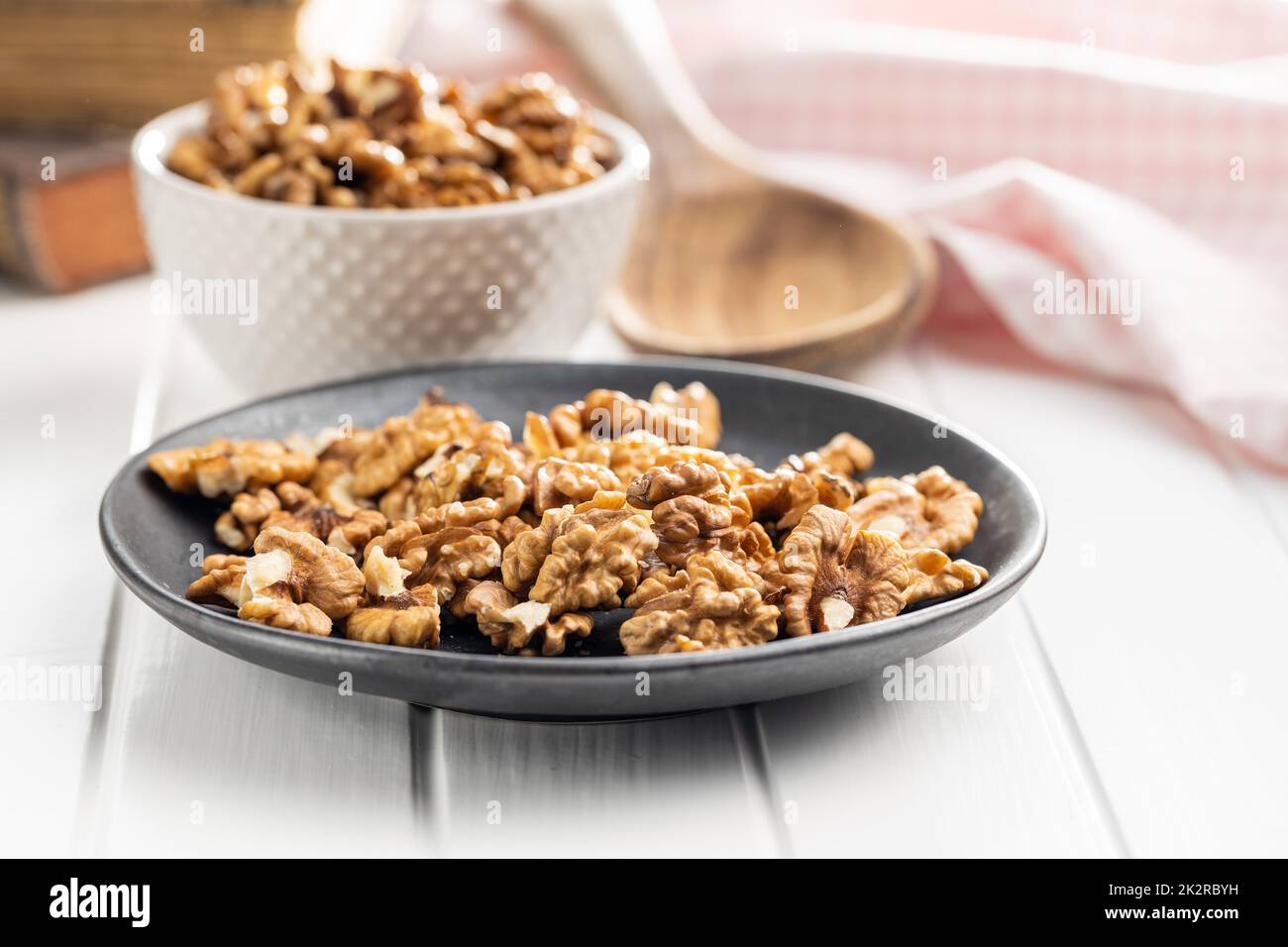 Peeled walnut kernels on plate on white table. Stock Photo