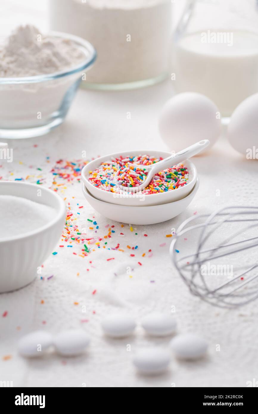 Baking background with flour, eggs, sugar sprinkles, kitchen tools, utensils Stock Photo