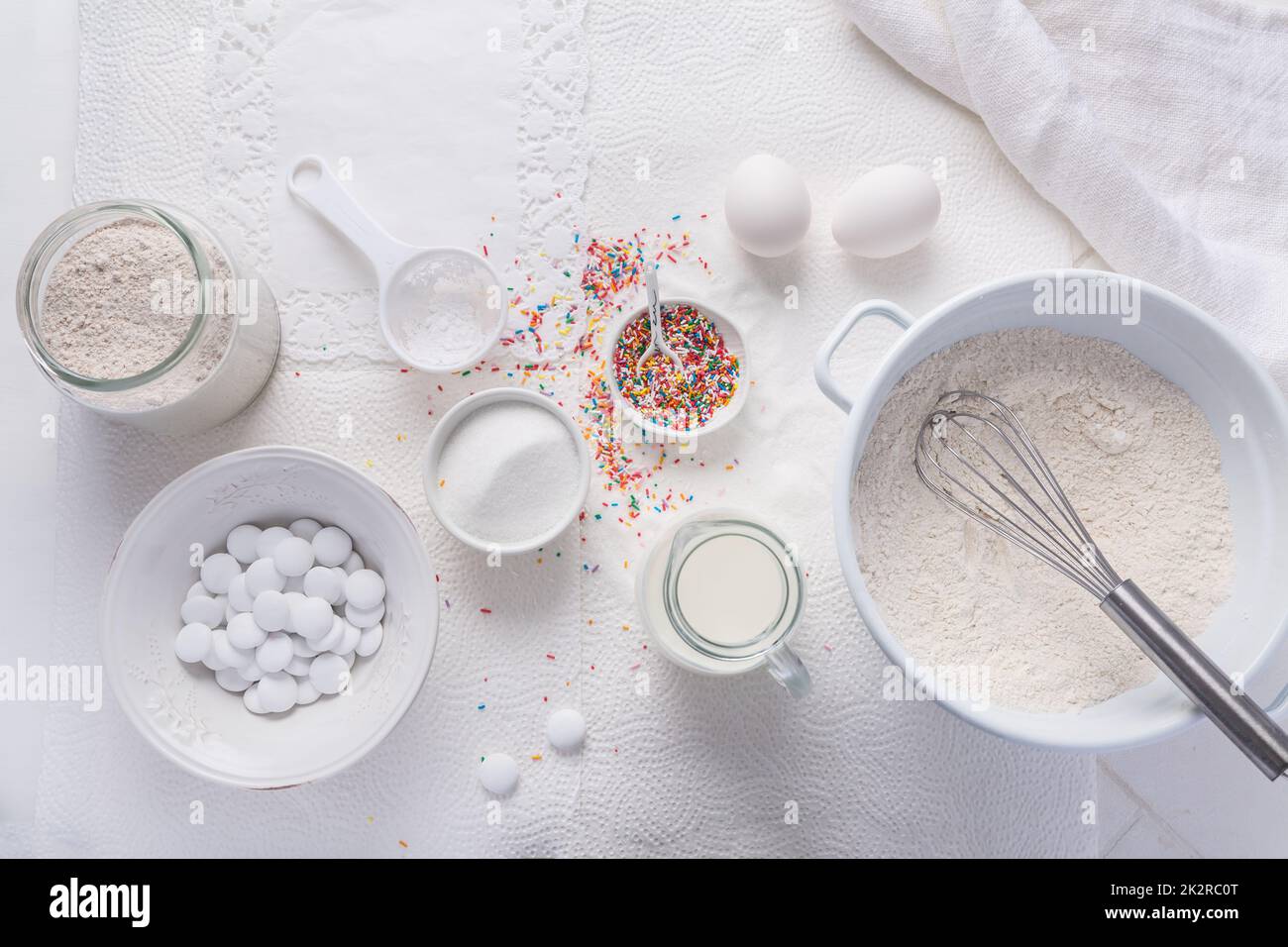 Baking background with flour, eggs, sugar sprinkles, kitchen tools, utensils Stock Photo