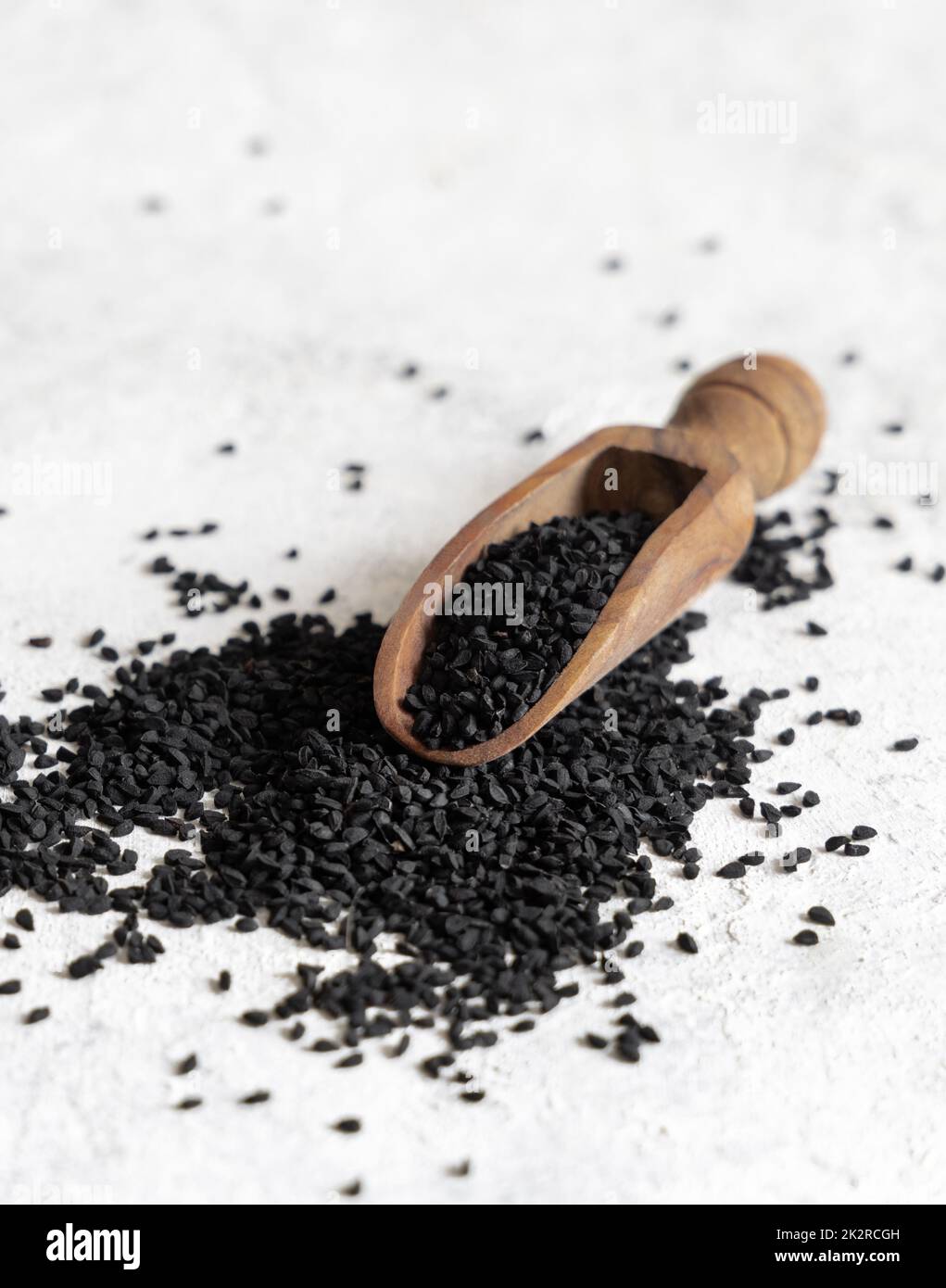 Wooden scoop of Indian spice Black cumin (nigella sativa or kalonji) seeds close up Stock Photo