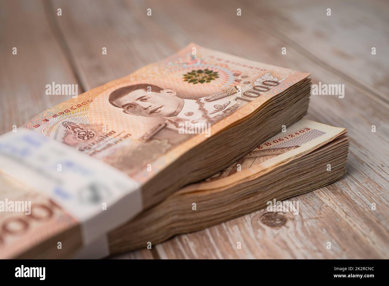 Stack of Thai baht banknotes on wooden background, business saving