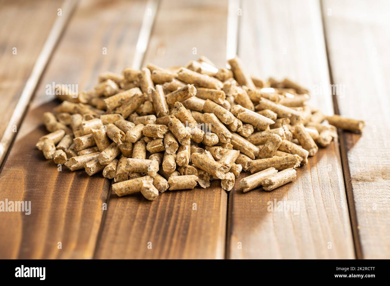 Wooden pellets, biofuel on wooden table. Ecologic fuel made from