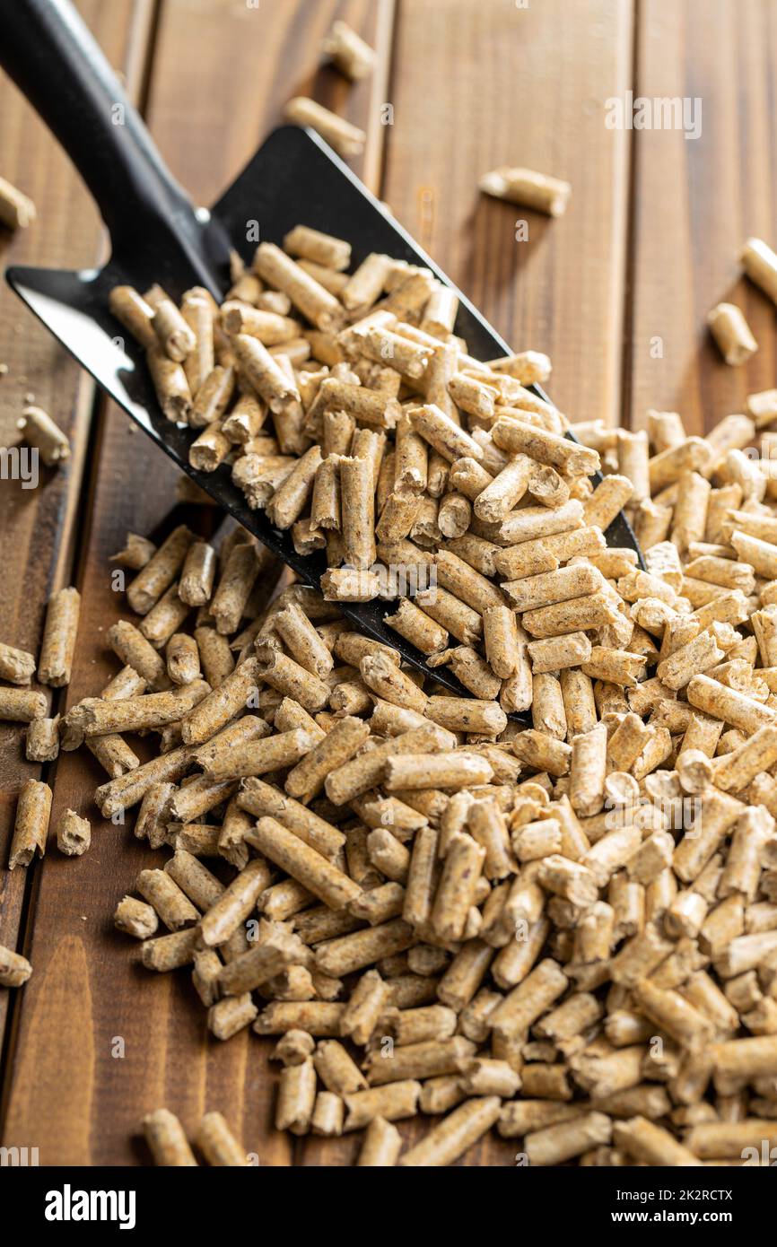 Wooden pellets, biofuel on wooden table. Ecologic fuel made from biomass. Renewable energy source. Stock Photo