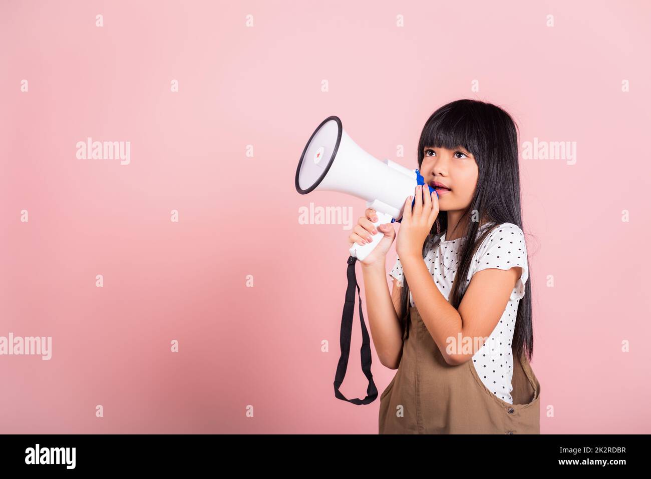 Asian little kid 10 years old shouting by megaphone Stock Photo