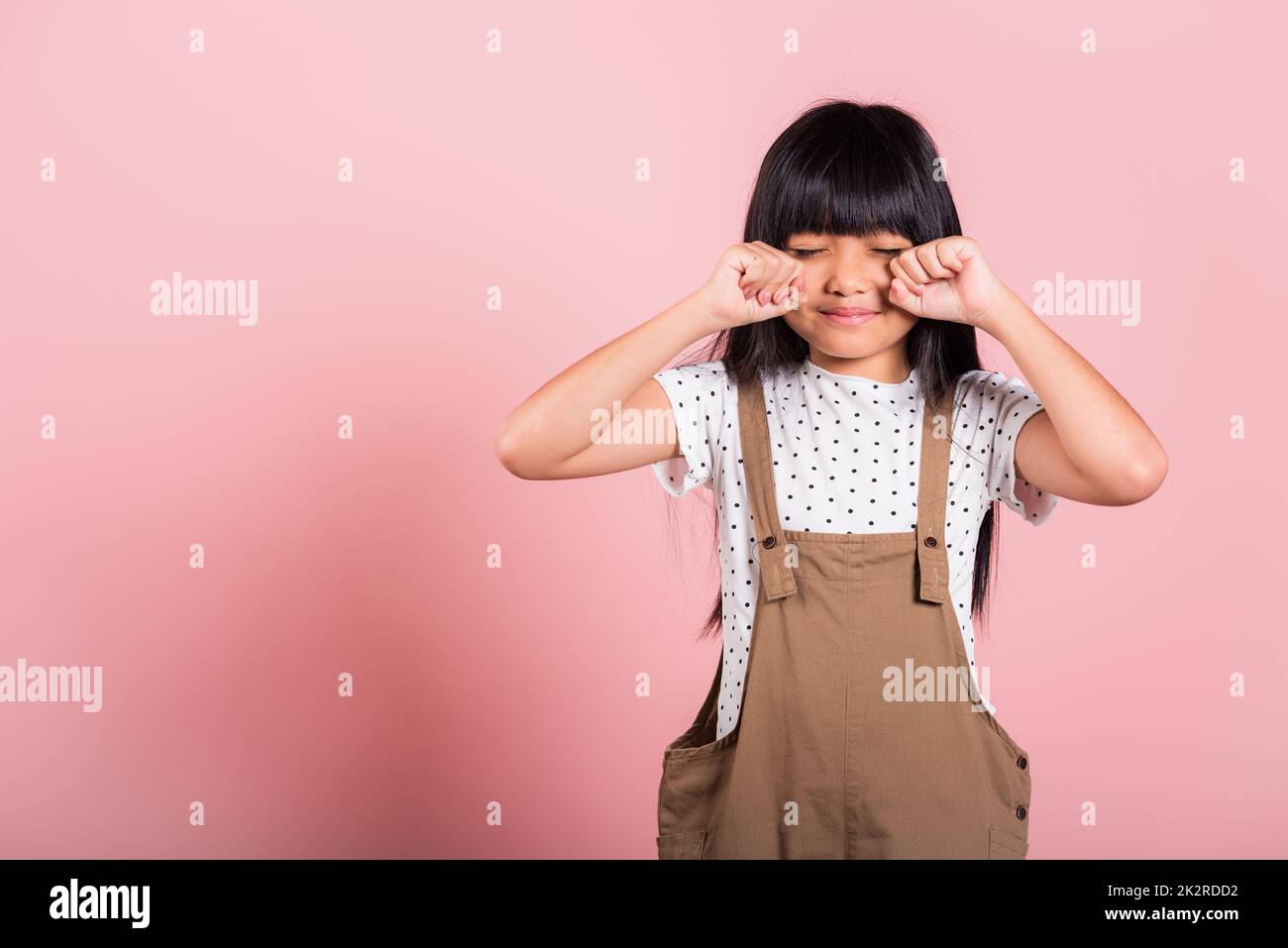 Asian little kid 10 years old bad mood her cry wipe tears with fingers Stock Photo