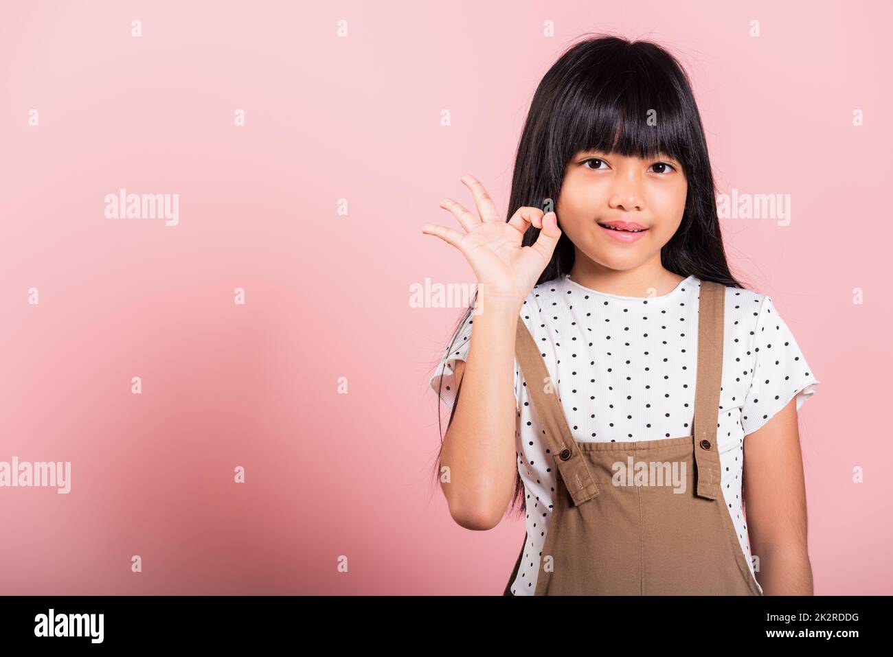 Asian little kid 10 years old showing OK gesture in sign language Stock Photo