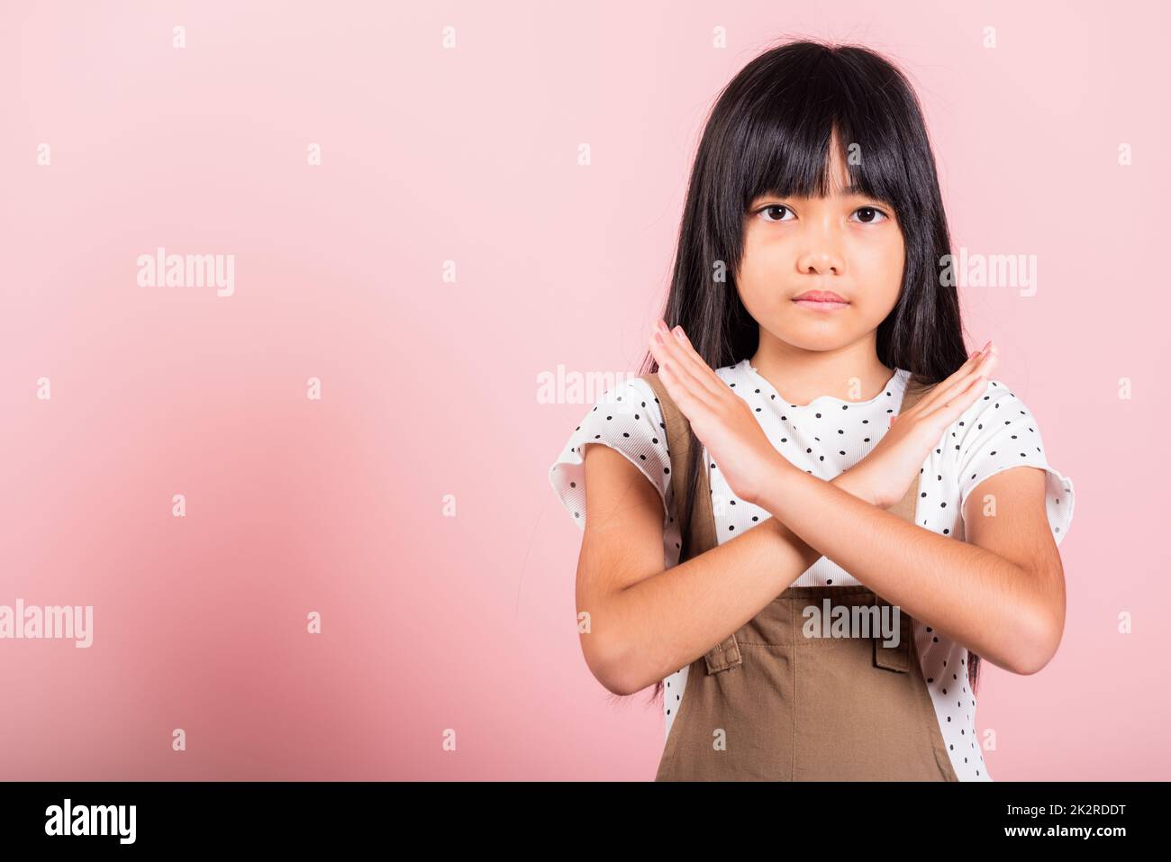 Asian little kid 10 years old showing two hands cross arms say no X sign Stock Photo