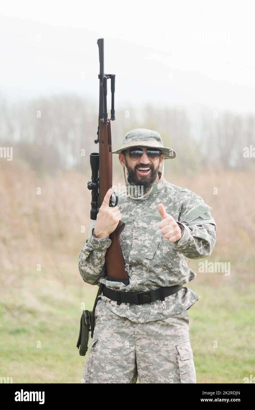 hunter with gun showing thumbs up Stock Photo