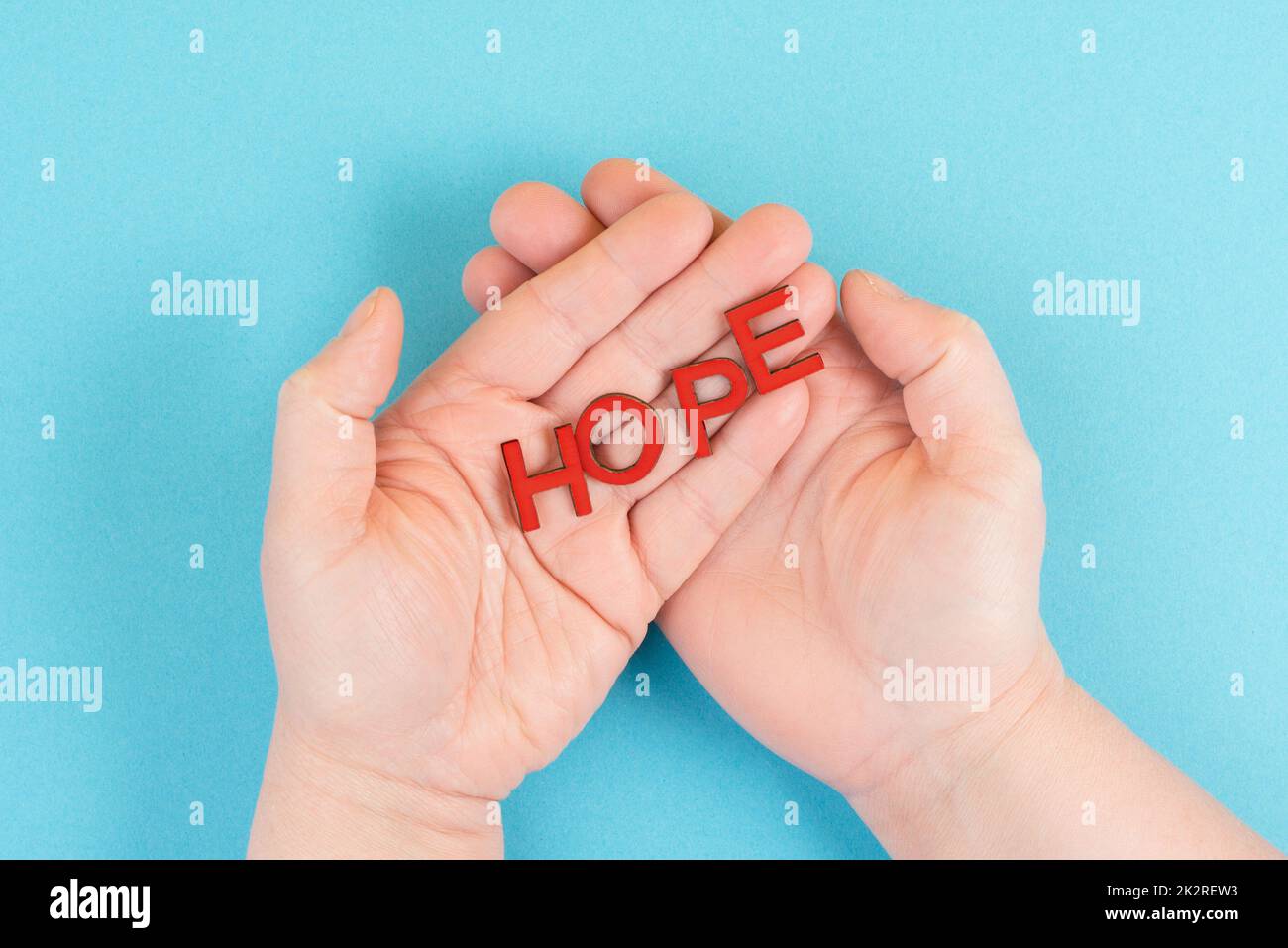 Holding the word hope in the palm of the hands, trust and believe