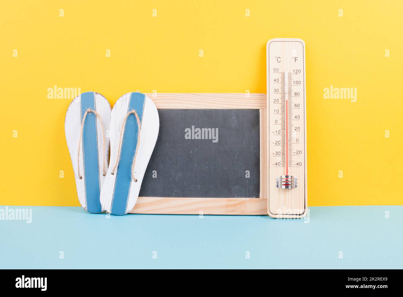 Empty chalkboard with a thermometer and flip flops, holiday background, summer vacation, hot weather, environmental issue Stock Photo