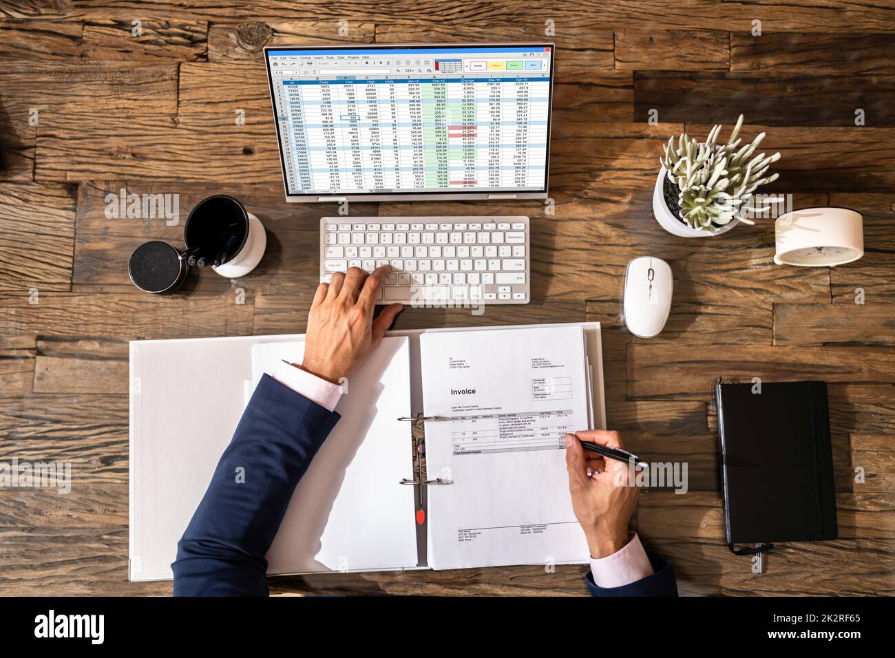 Looking At Invoice And Spreadsheet On Computer Stock Photo