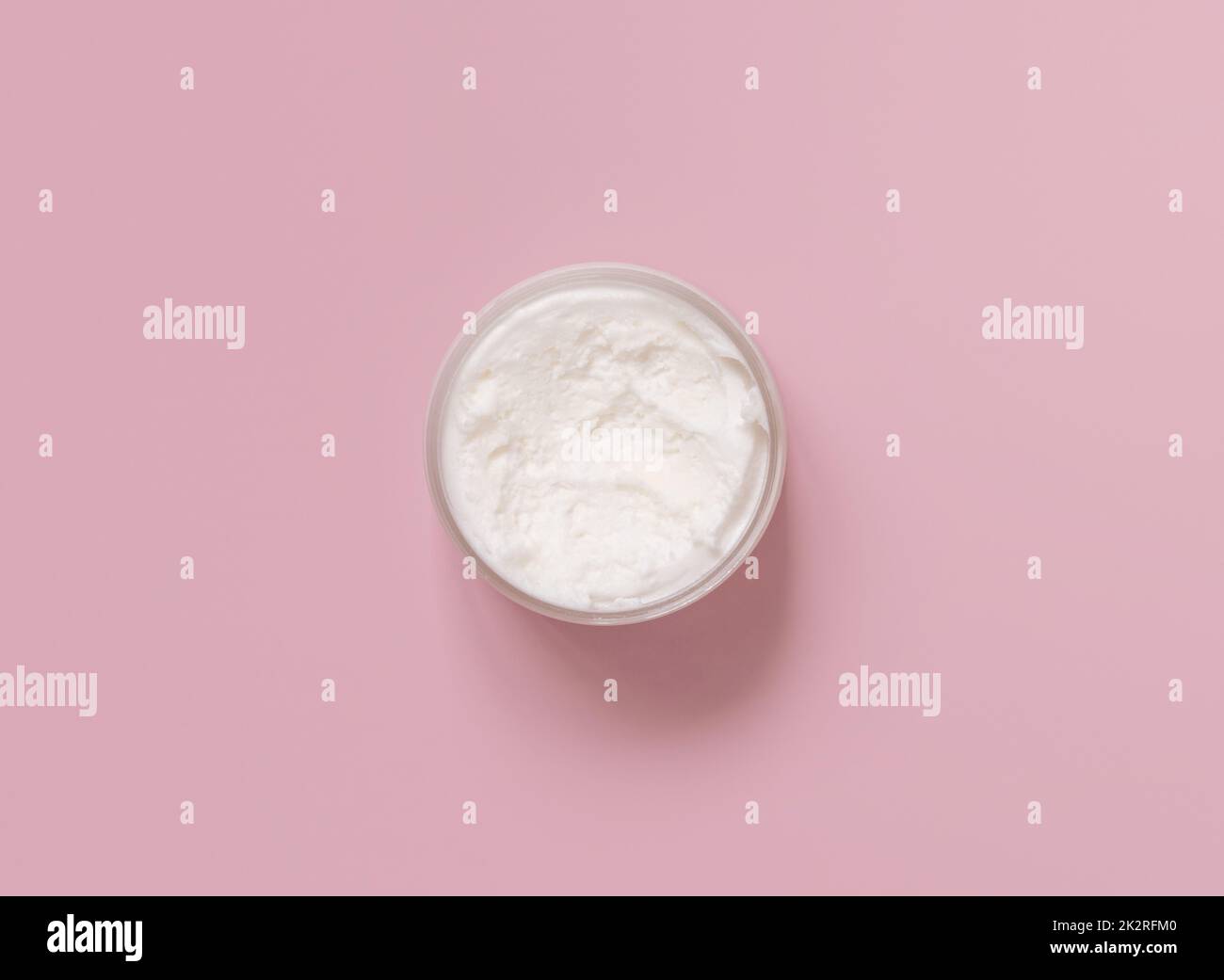 Homemade cream in plastic jar on light pink top view. Brand packaging mockup Stock Photo