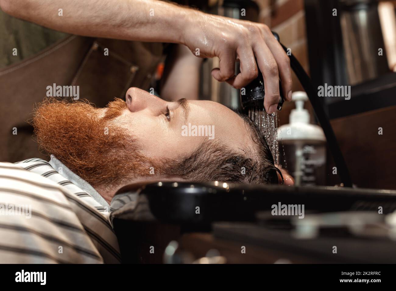 Barber and bearded man in barber shop Stock Photo