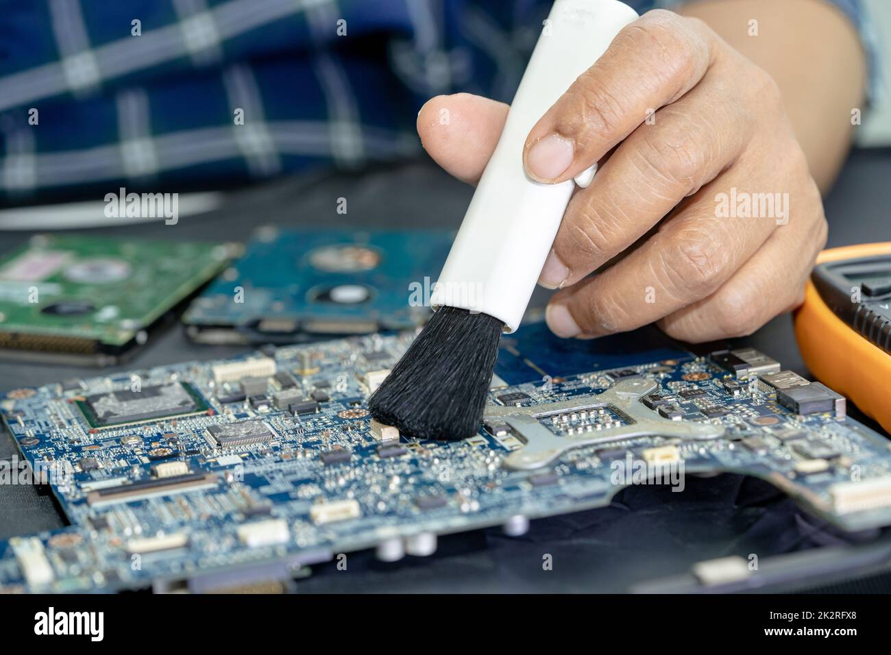 Technician use brush and air blower ball to clean dust in circuit board computer. Repair upgrade and maintenance technology. Stock Photo
