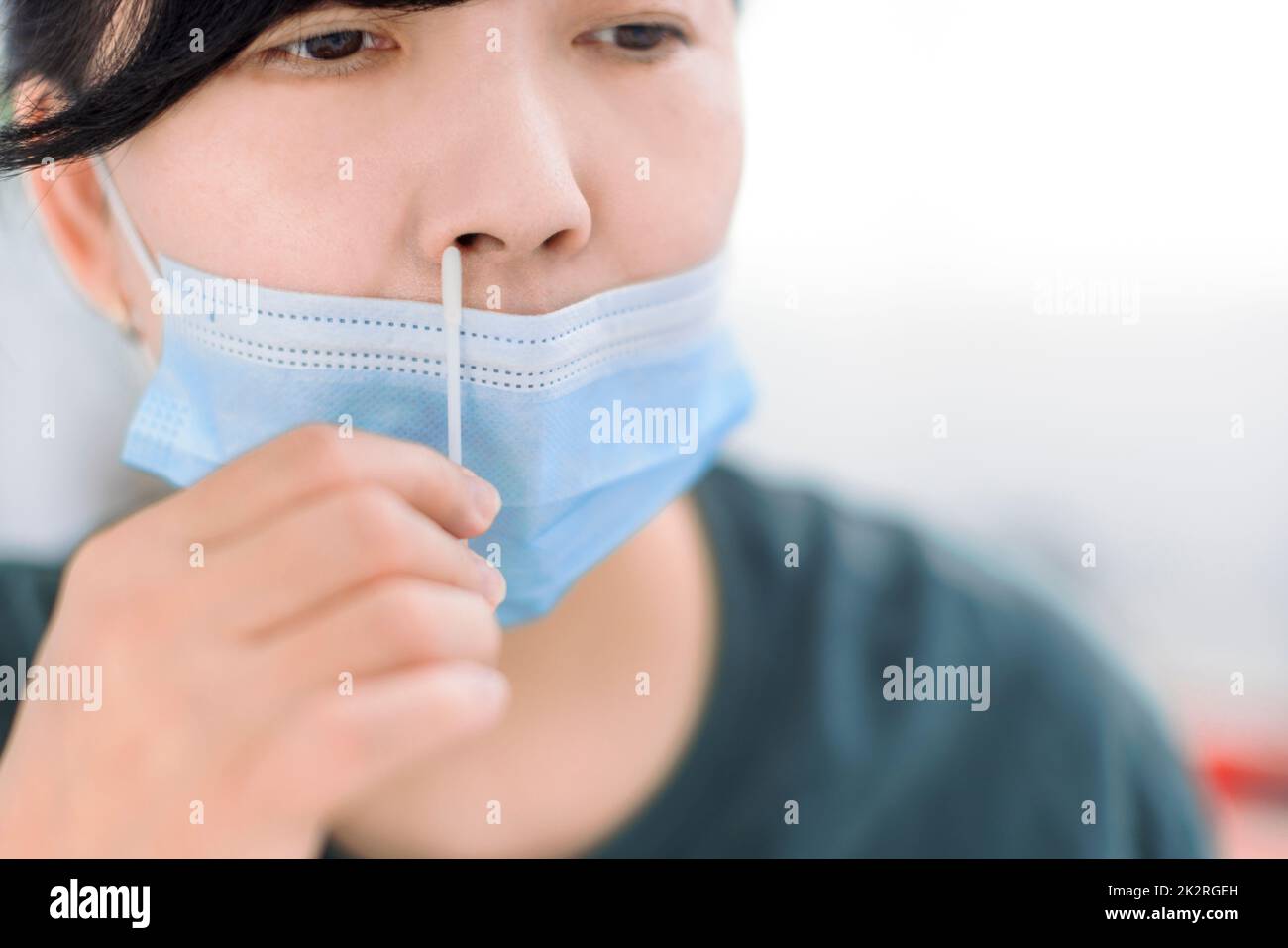 Woman using covid19 rapid antigen self test kit at home with a cotton