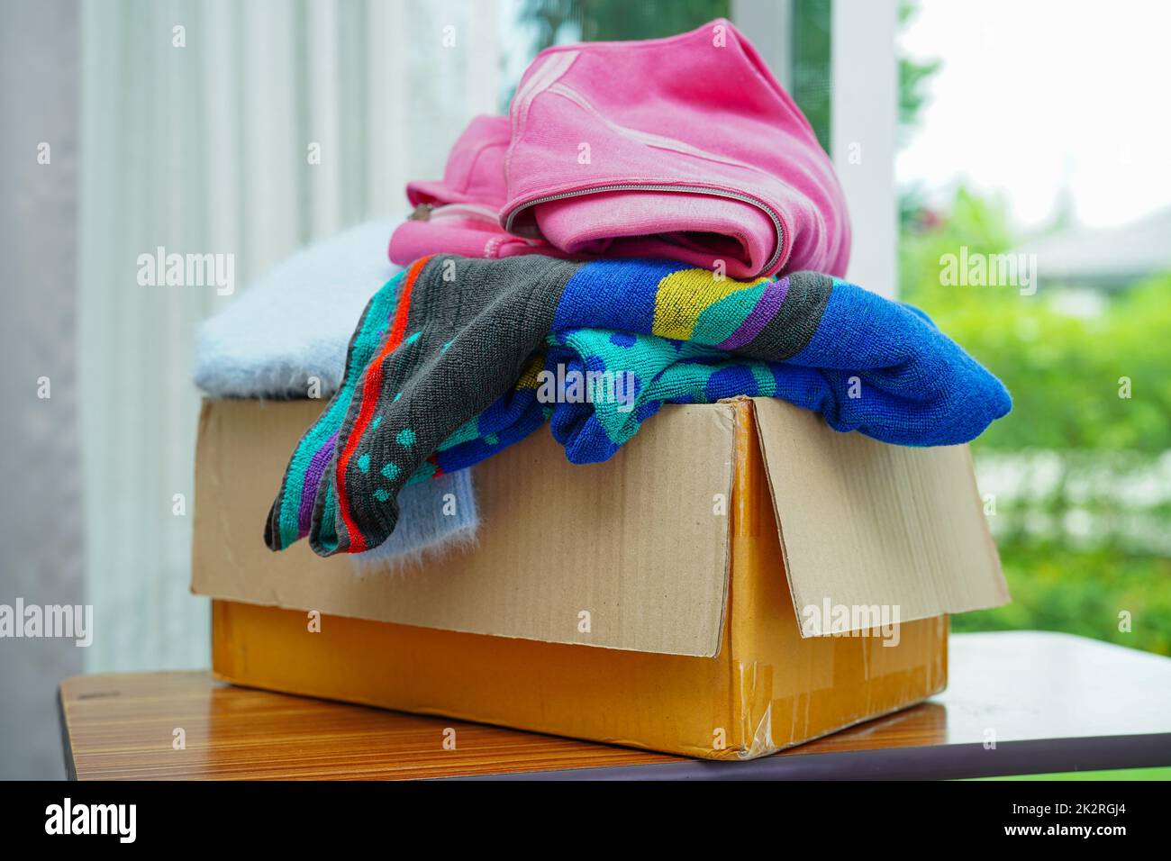 Clothes donations in cardboard box for volunteer Stock Photo Alamy