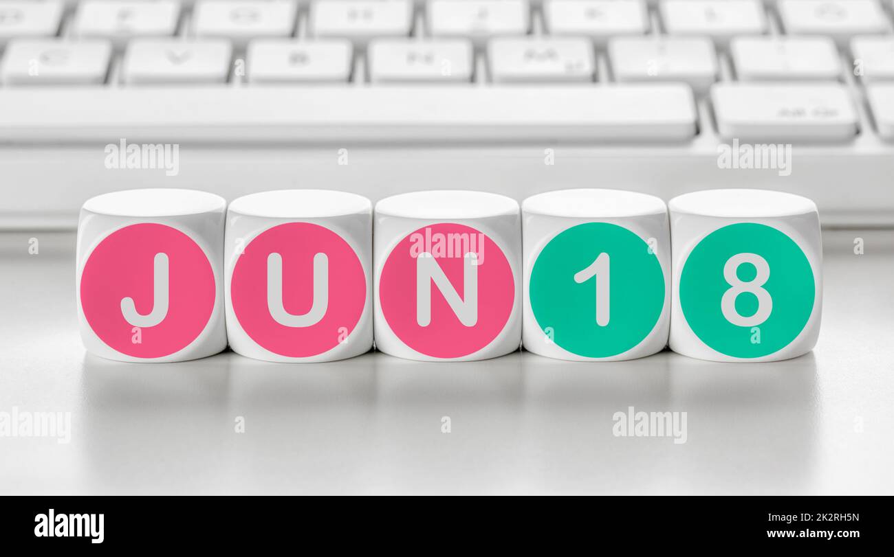 Letter dice in front of a keyboard - June 18 Stock Photo