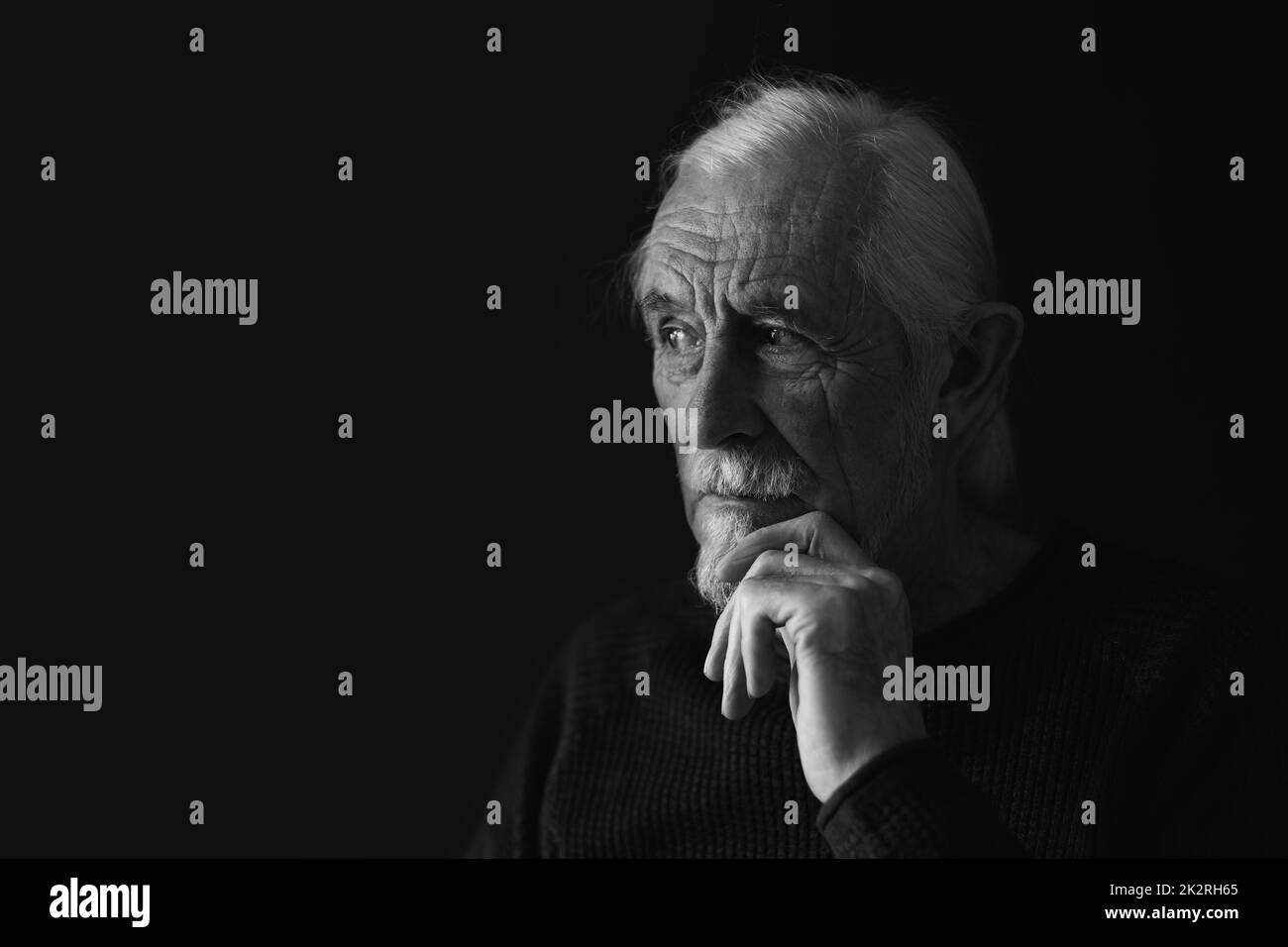 Black and white studio portrait of pensive old man Stock Photo
