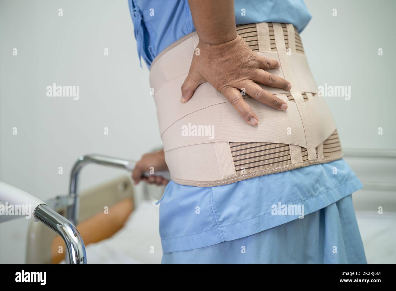 Asian lady patient wearing back pain support belt for orthopedic lumbar