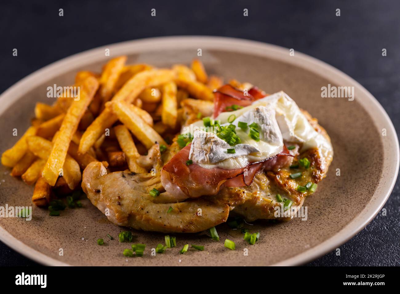 typical czech cuisine chicken slice baked with ham and camembert with french fries Stock Photo