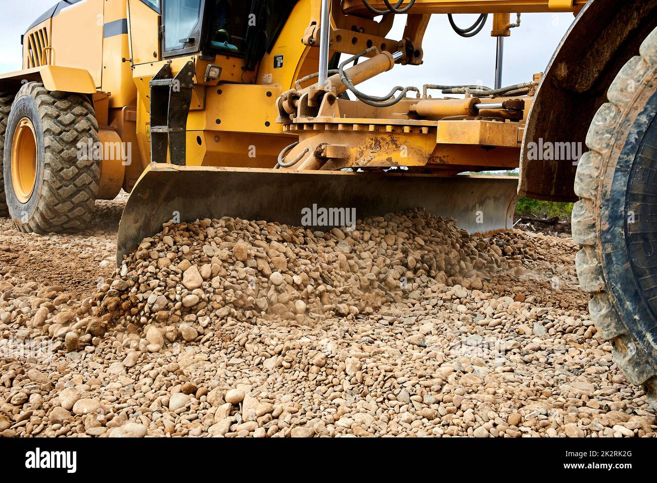 the grader blade levels the rubble at the construction site Stock Photo