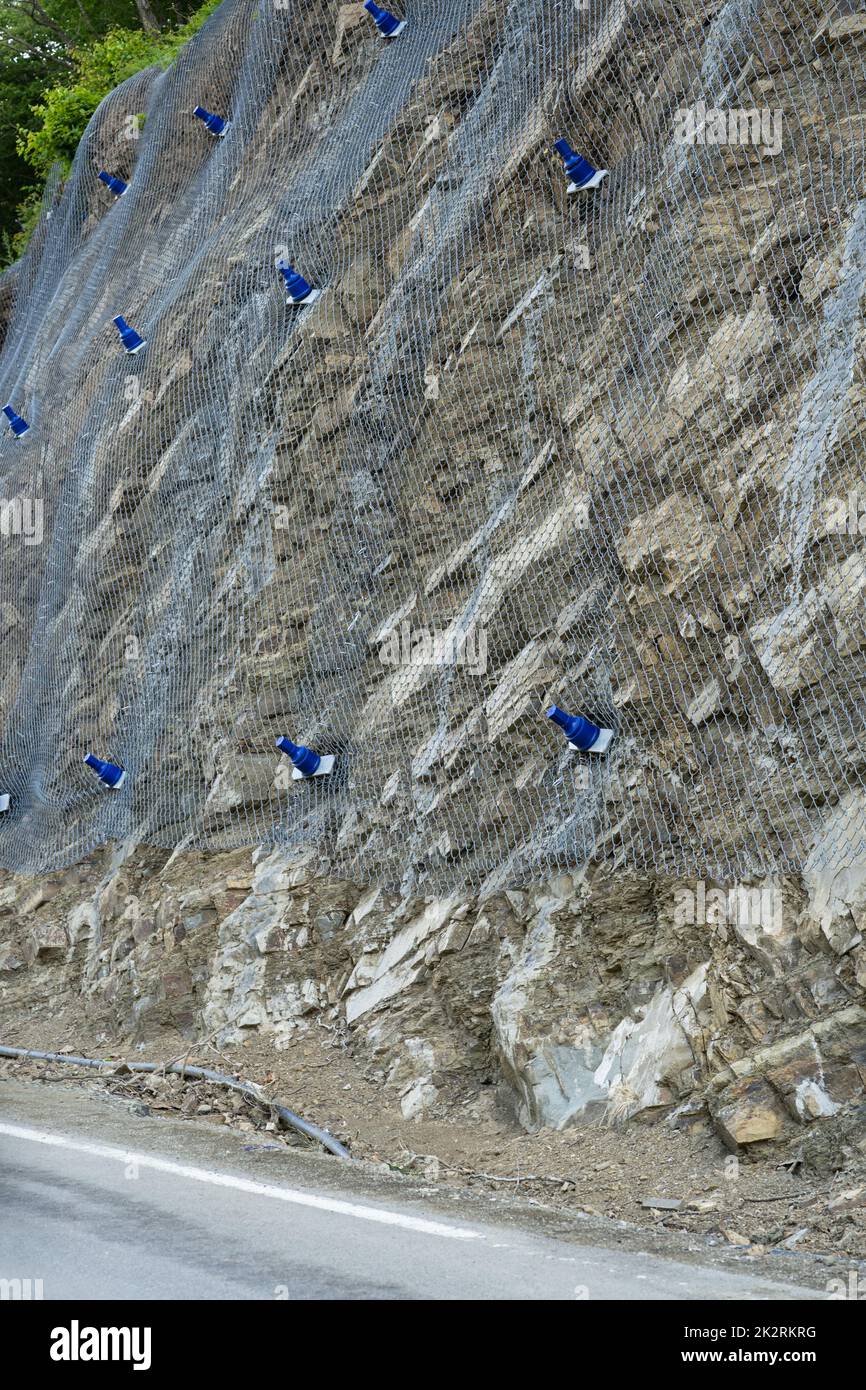 Landslide and rock sliding prevention in Georgia, reinforcing mountain slope with metal mesh.  Stock Photo
