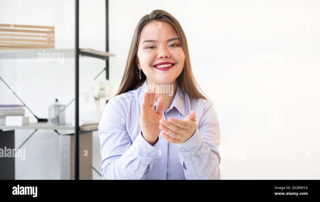 Successful career. Corporate congratulation. Professional growth. Goal achievement. Cheerful satisfied business woman smiling applauding in light home Stock Photo