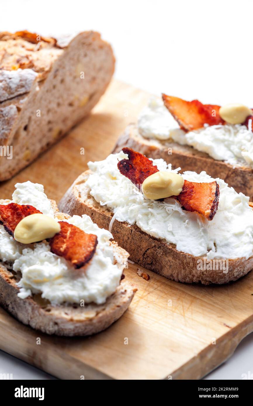 garlic spread on slice of bread served with bacon, grated cheese and