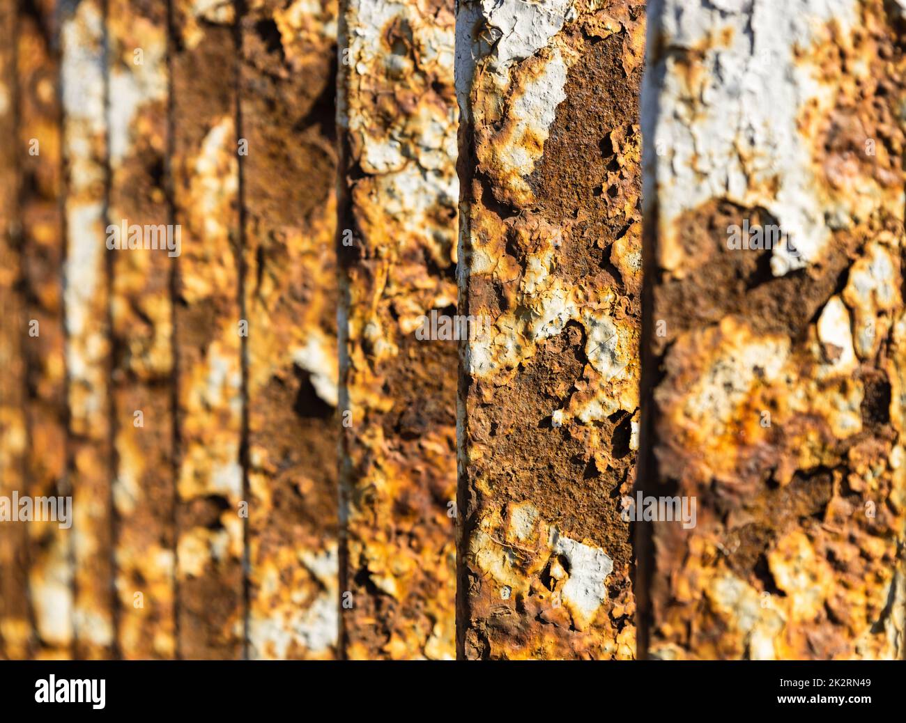 Metal bridge railing with corrosion, rust, deep cracks, and paint flaking texture Stock Photo