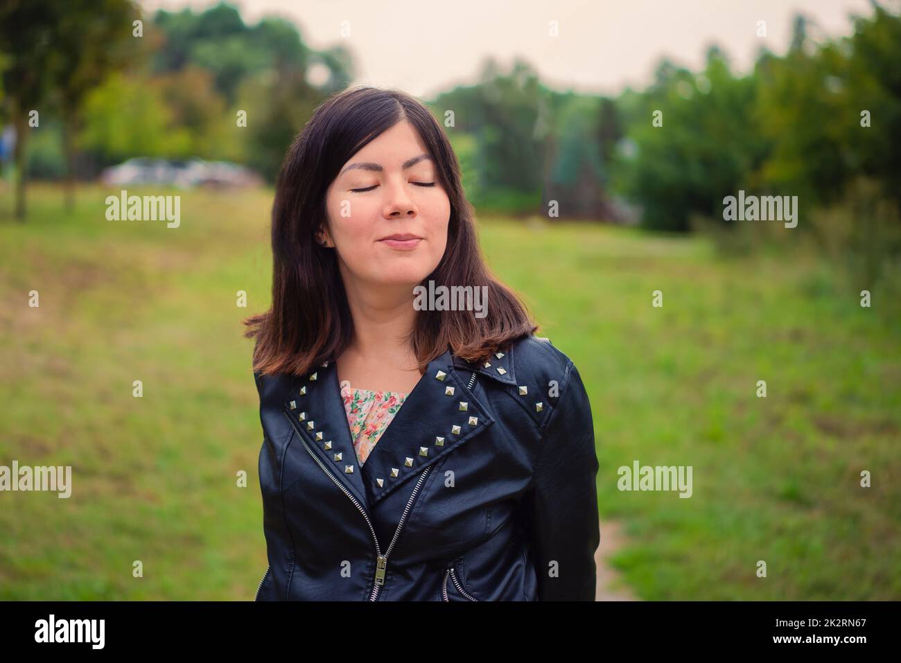 Close portrait of a cute young black-haired girl with closed eyes Stock Photo