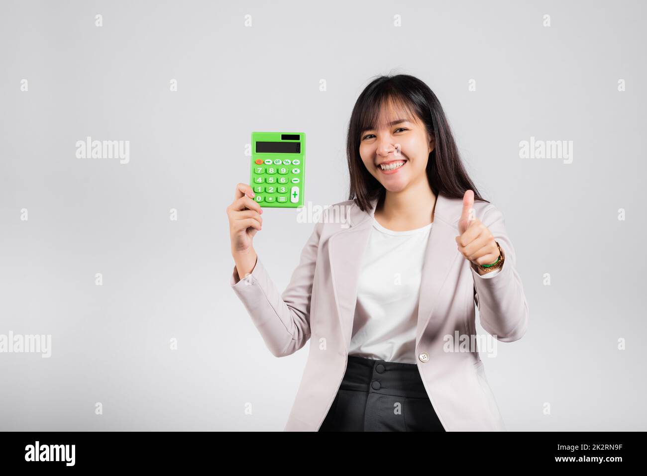 Woman confident smiling holding electronic calculator and show thumb up ...