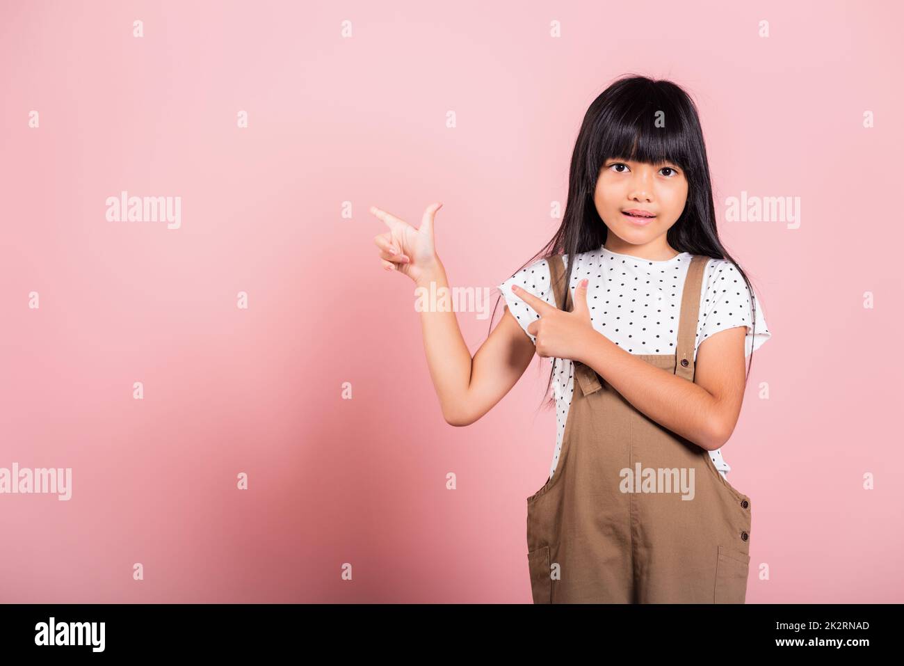 Asian little kid 10 years old point with index finger up Stock Photo