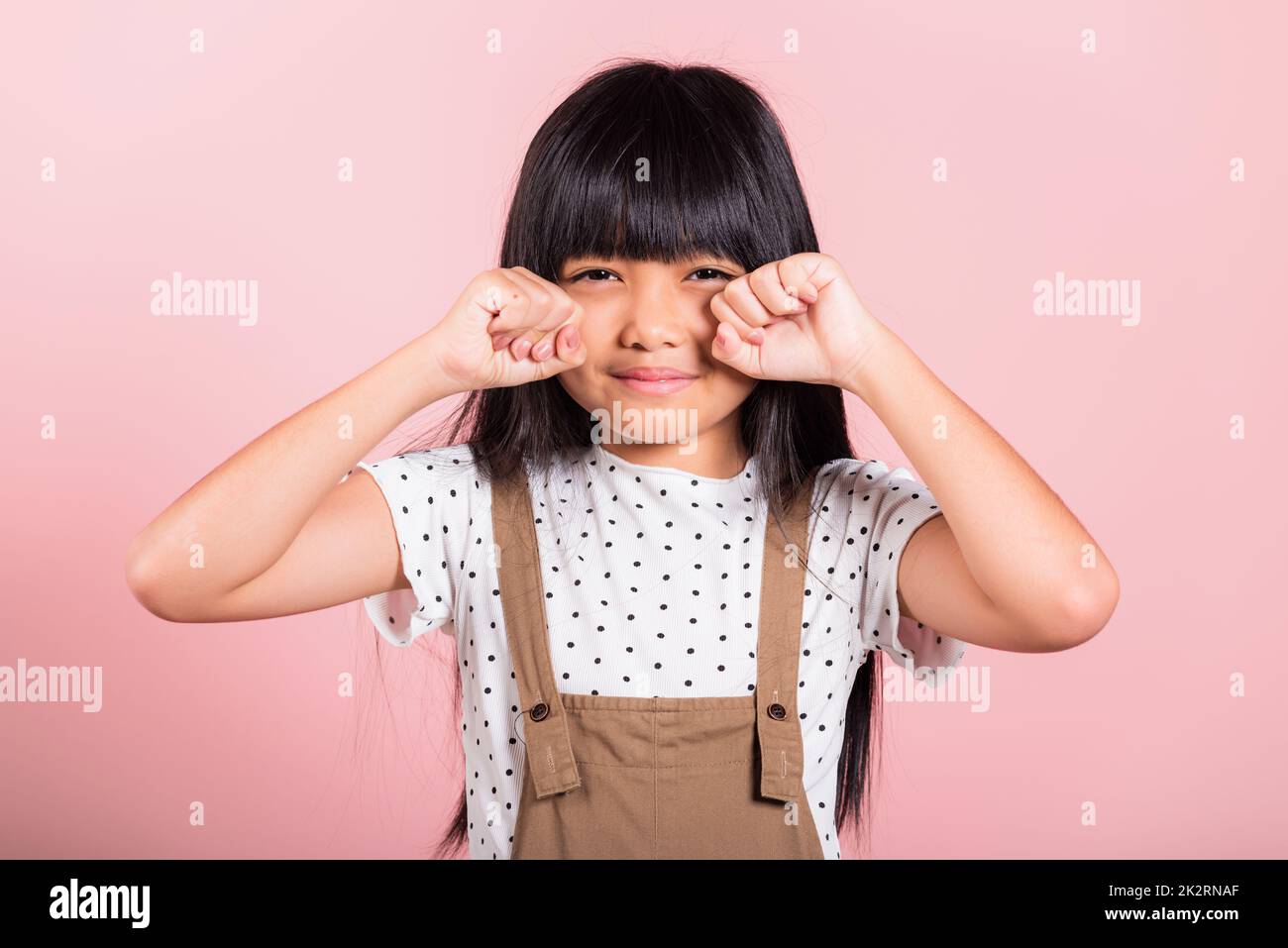Asian little kid 10 years old bad mood her cry wipe tears with fingers Stock Photo