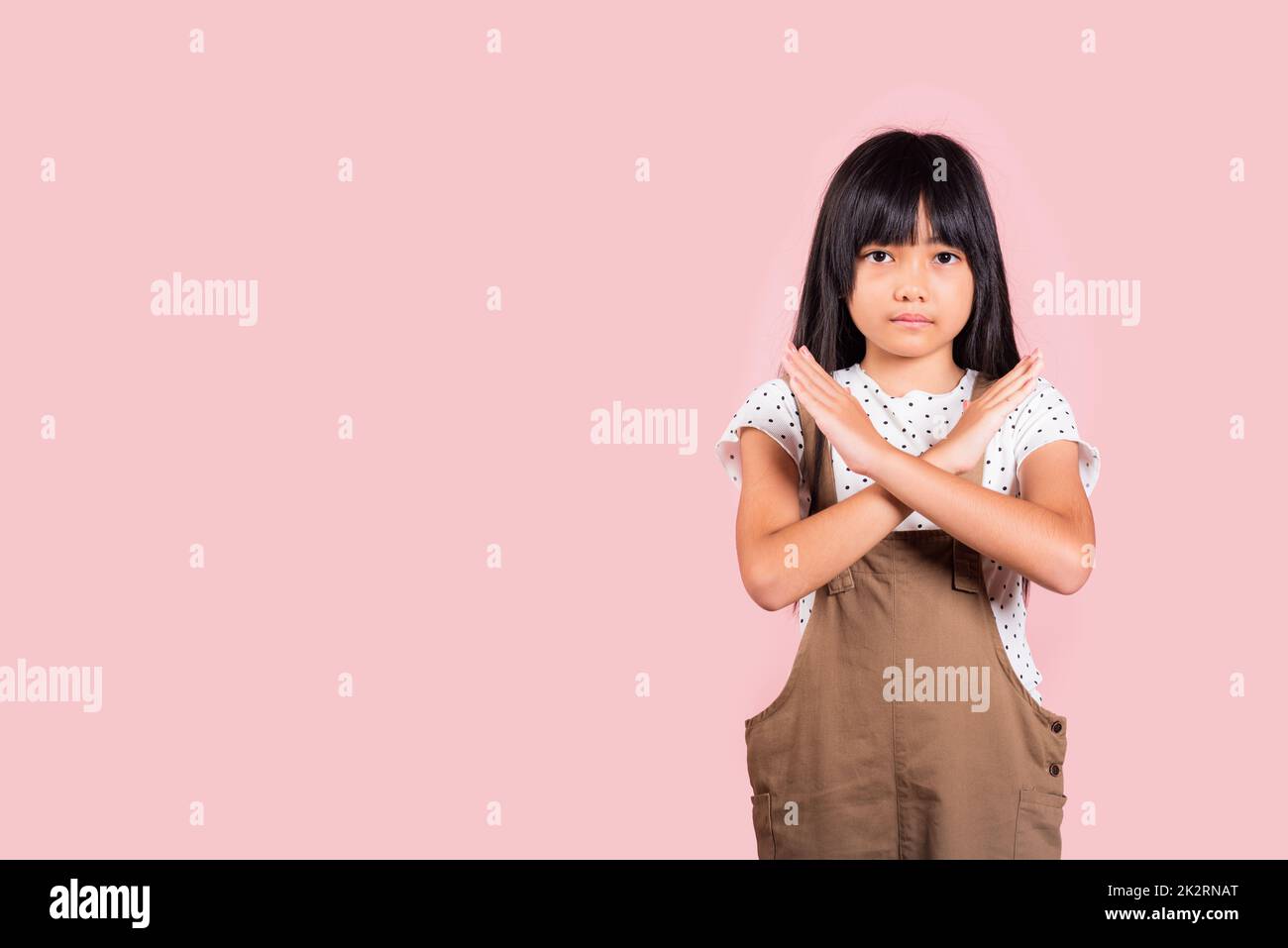 Asian little kid 10 years old showing two hands cross arms say no X sign Stock Photo