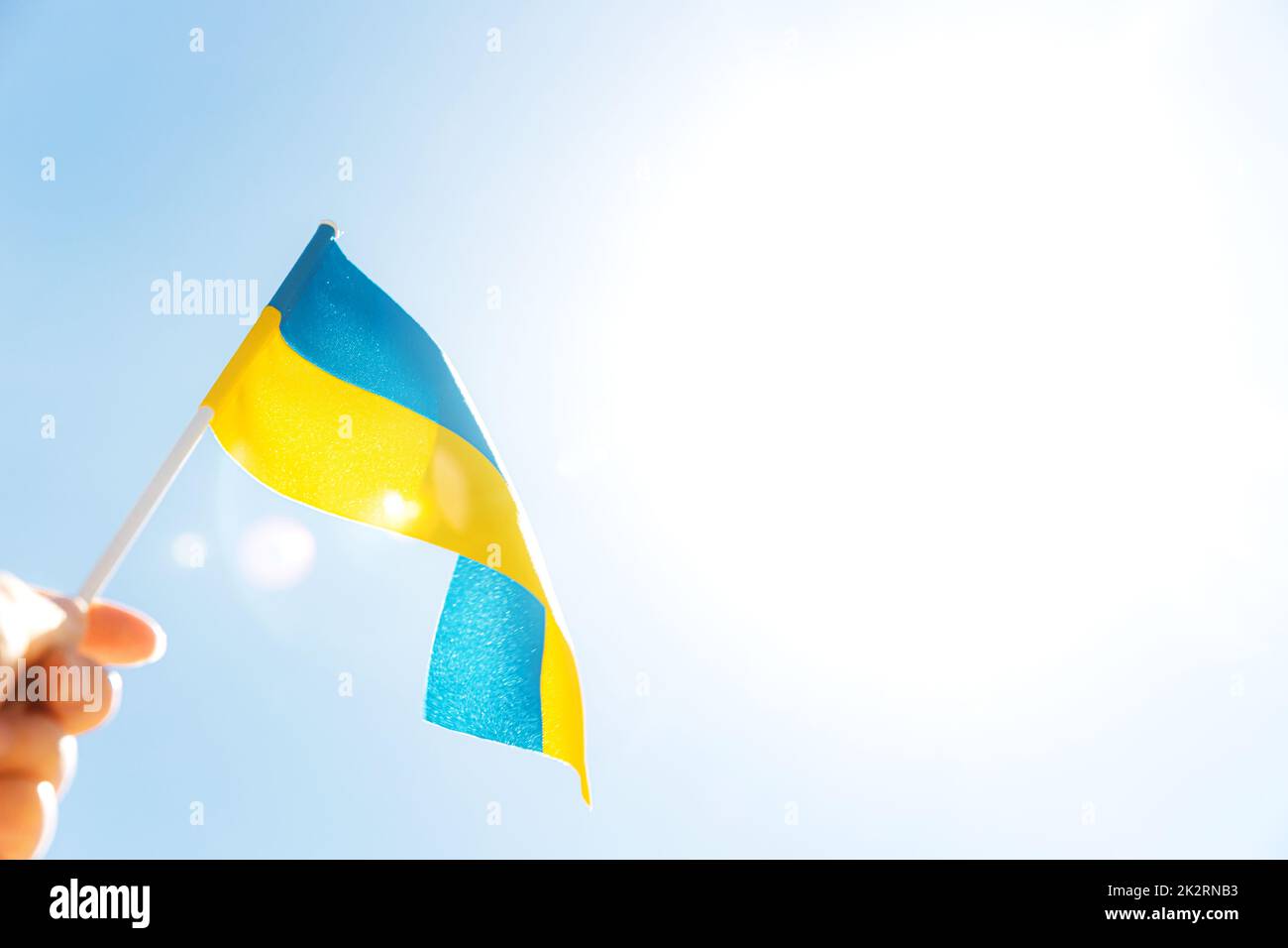 Hand holding large bicolor yellow blue Ukrainian state flag Stock Photo