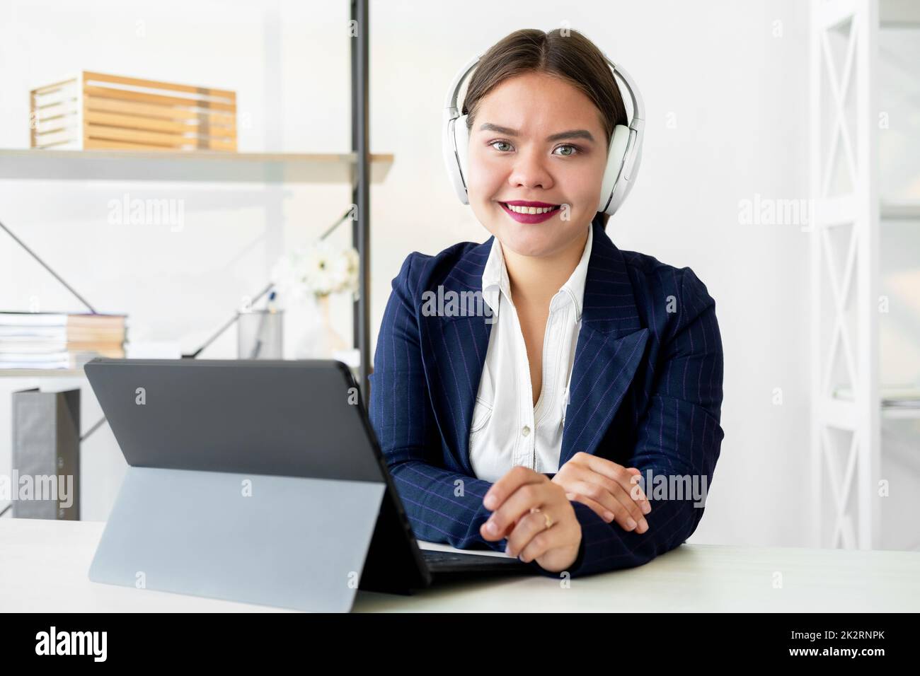 Online learning. Business coaching. Internet communication. Video conference. Cheerful successful woman in white headphones working from home office w Stock Photo