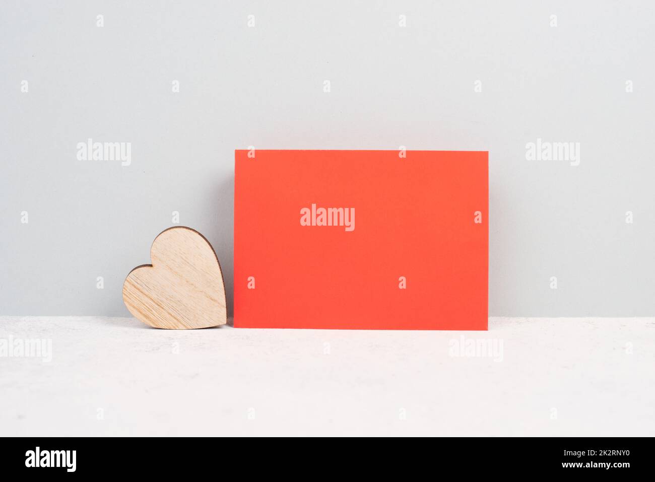 Red envelope with an empty paper, wooden heart, textured background, birthday, mothers day, fathers day and valintines day greeting card Stock Photo