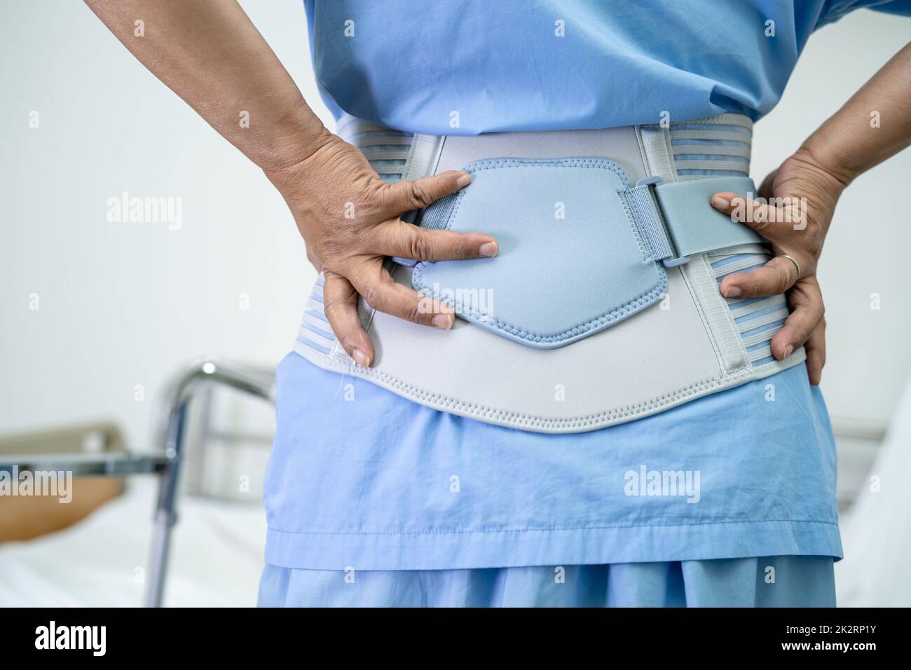 Asian lady patient wearing back pain support belt for orthopedic lumbar ...