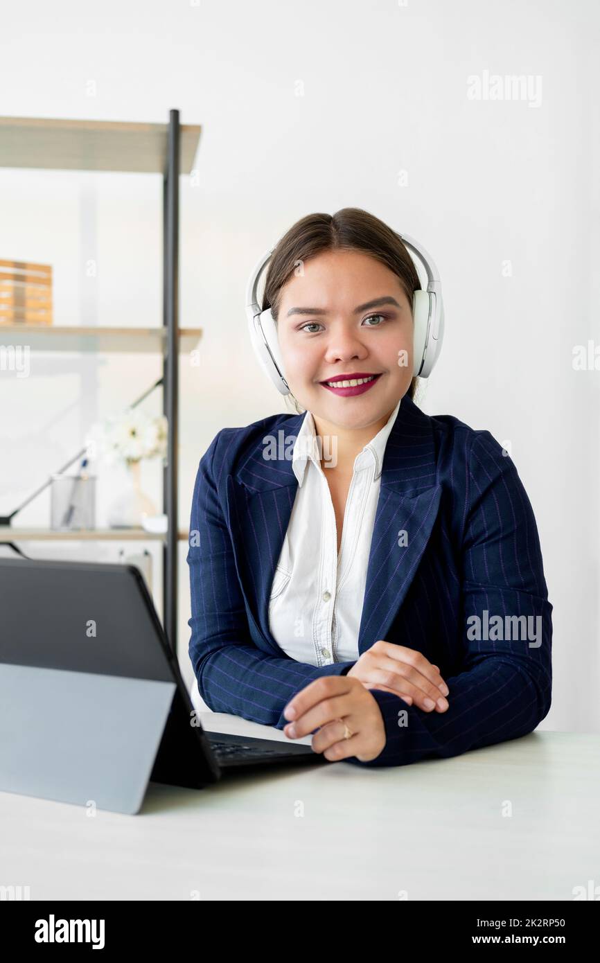 Corporate webinar. Zoom videocall. Online communication. Remote conference. Cheerful confident woman in white headphones working from home office with Stock Photo