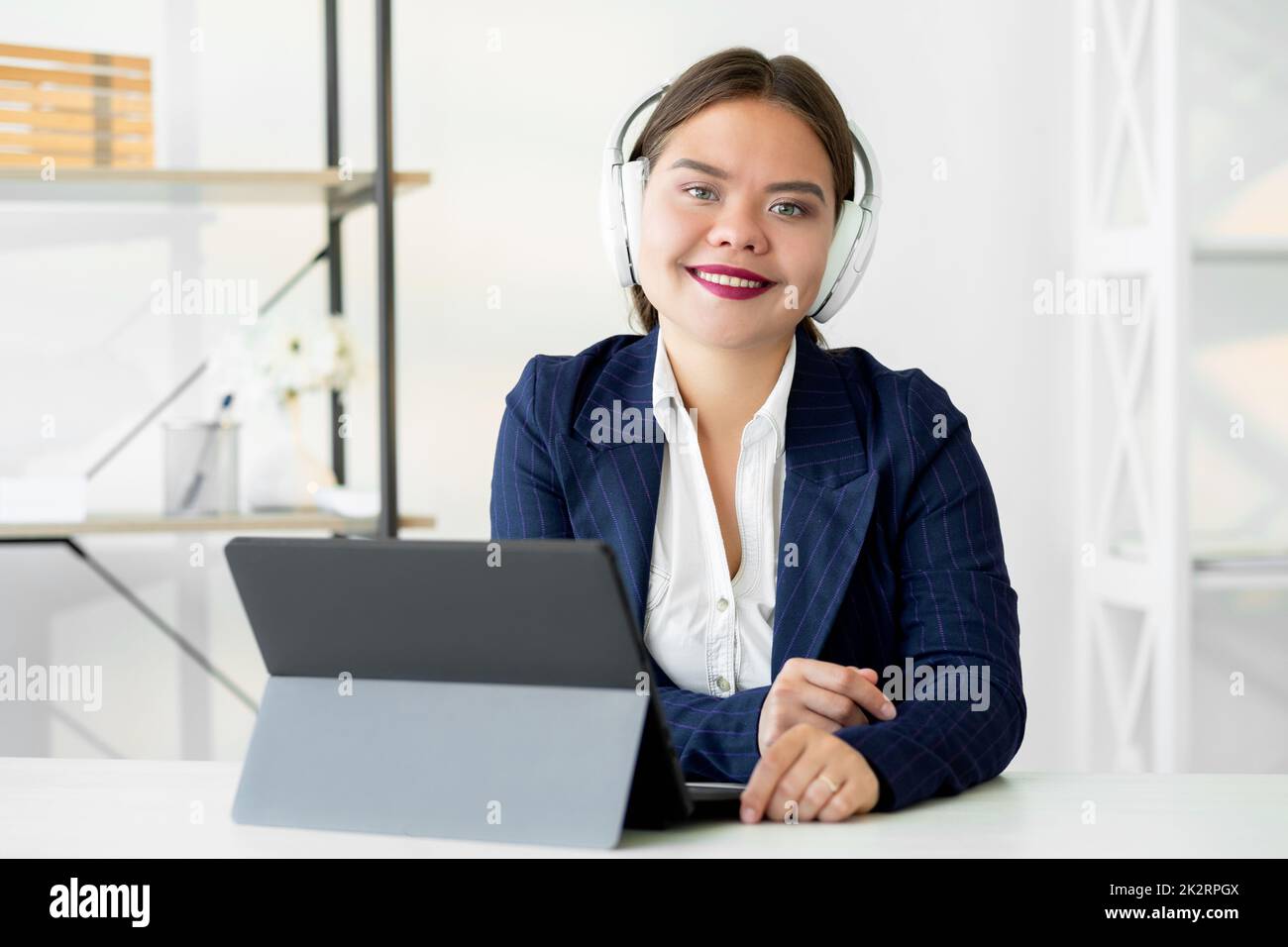 Video conference. Business webinar. Online communication. Virtual corporate meeting. Cheerful confident woman in white headphones working from home of Stock Photo