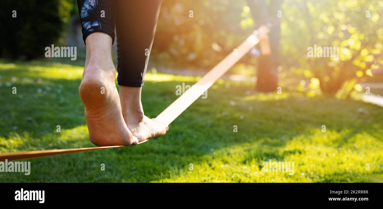 person walking on a slackline barefoot. strength and balance exercises Stock Photo