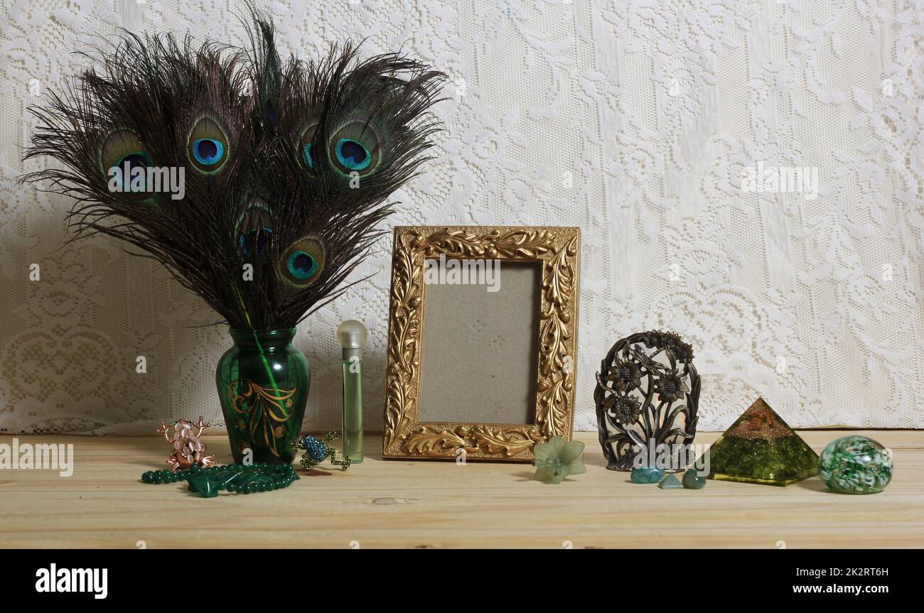 Vase of Peacock Feathers With Green Jewelry and Gold Photo Frame Stock