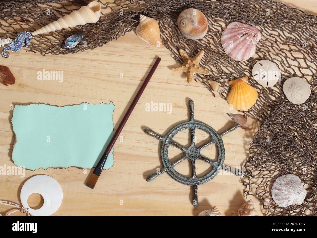 Blank Paper With Burned Edges on Wooden Background With Sea Shells and Fishing Net. Nautical and Coastal Theme Stock Photo