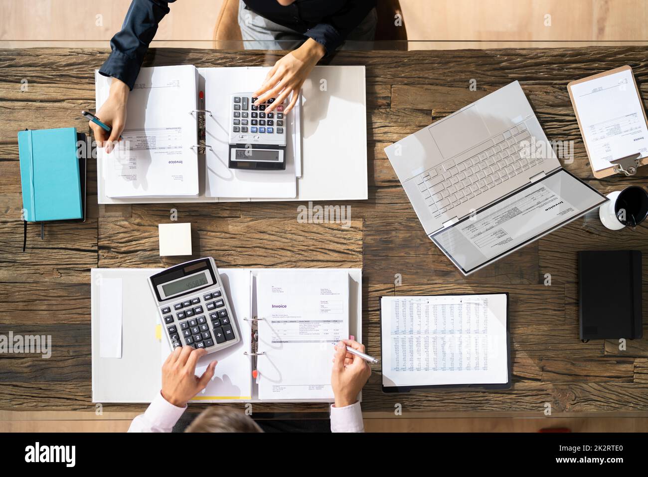 Two Businesspeople Calculating Bills In Office Stock Photo