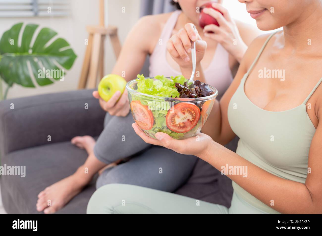 Two bautiful women having healthy breakfast at home after yoga workout with happiness Stock Photo