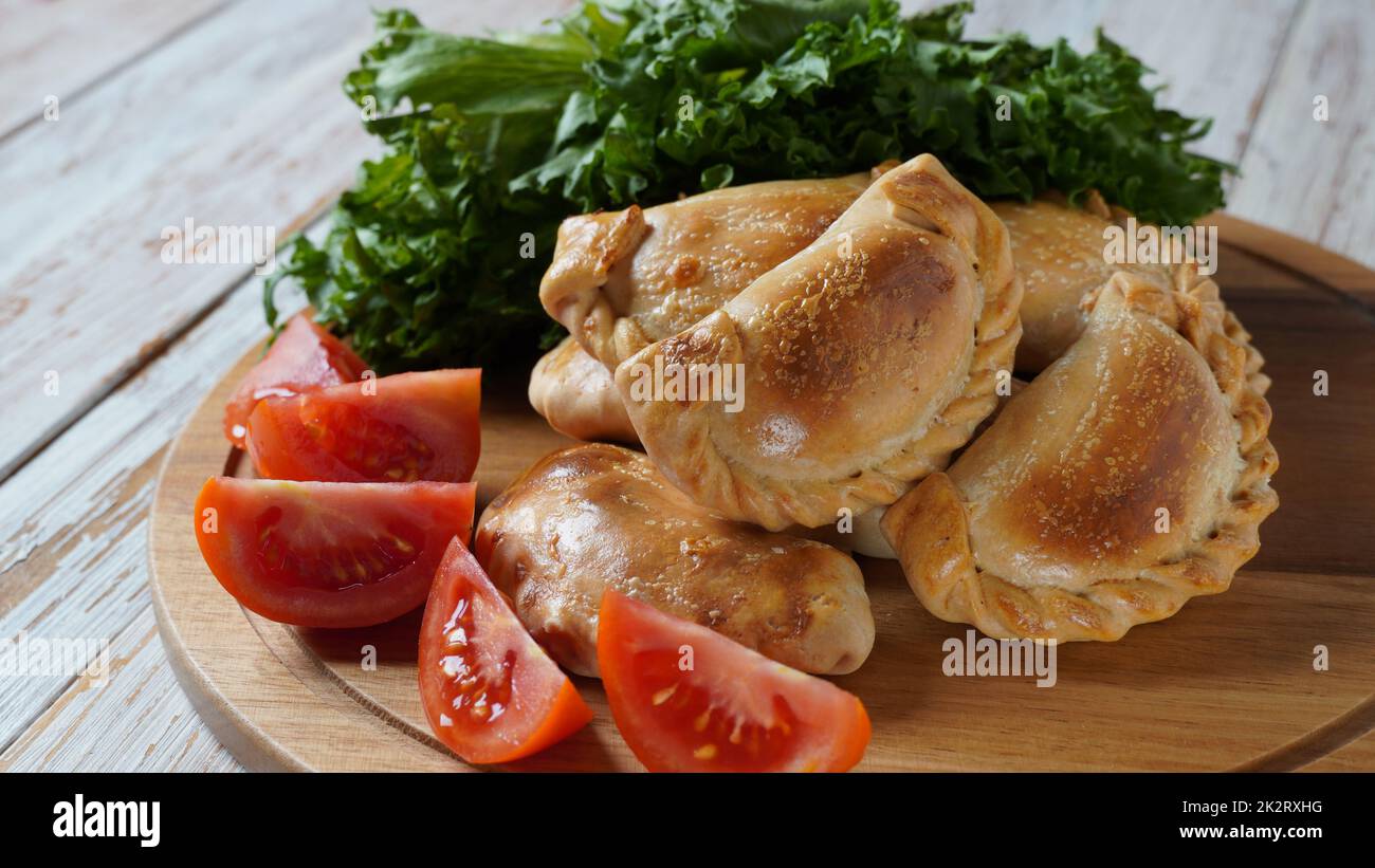 Latin American fried empanadas with tomato sauce. Argentinian Empanada is a pastry turnover filled with a variety of savory ingredients and baked or fried. Stock Photo