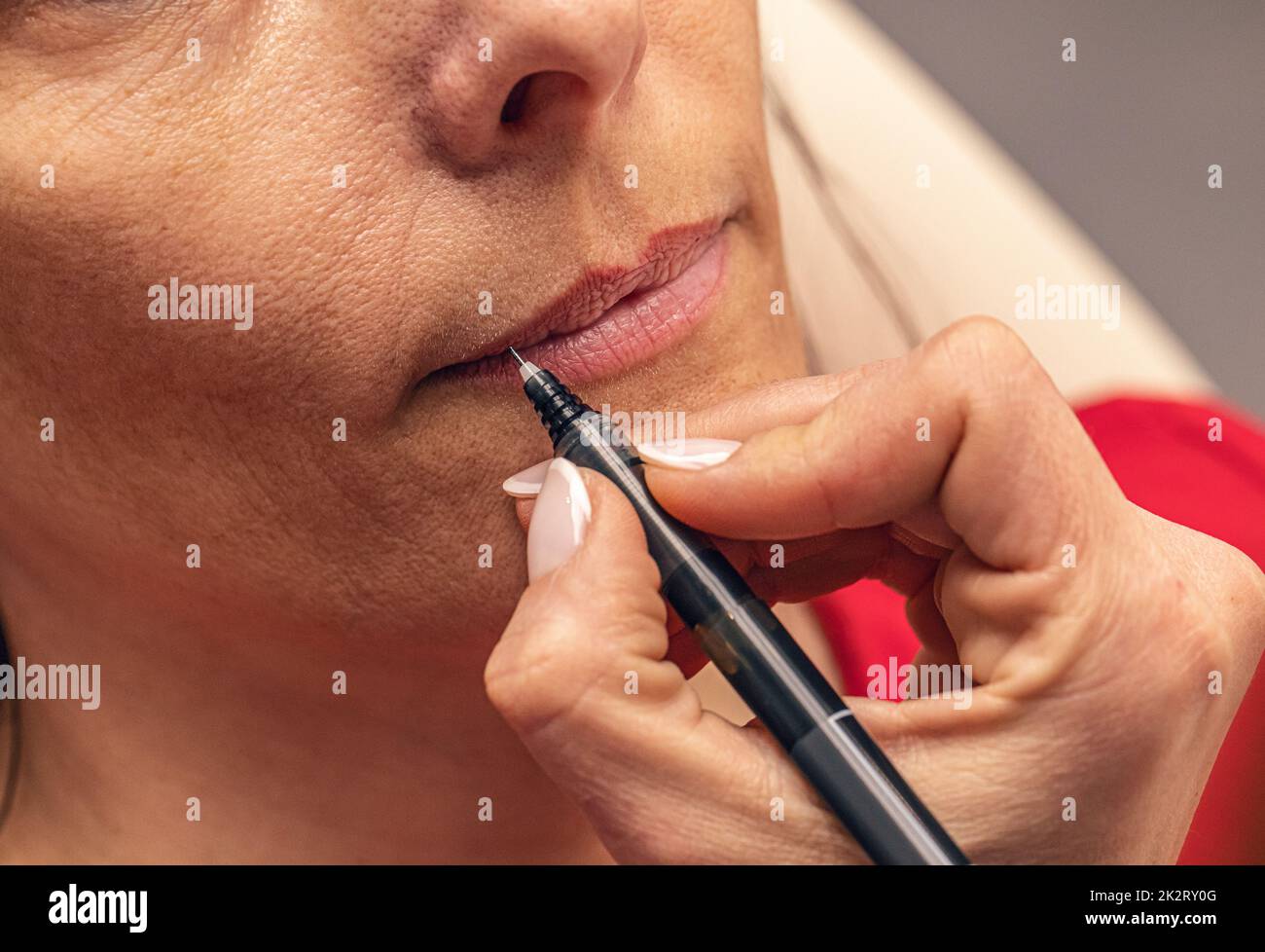 Cosmetician drawing lines on mouth Stock Photo