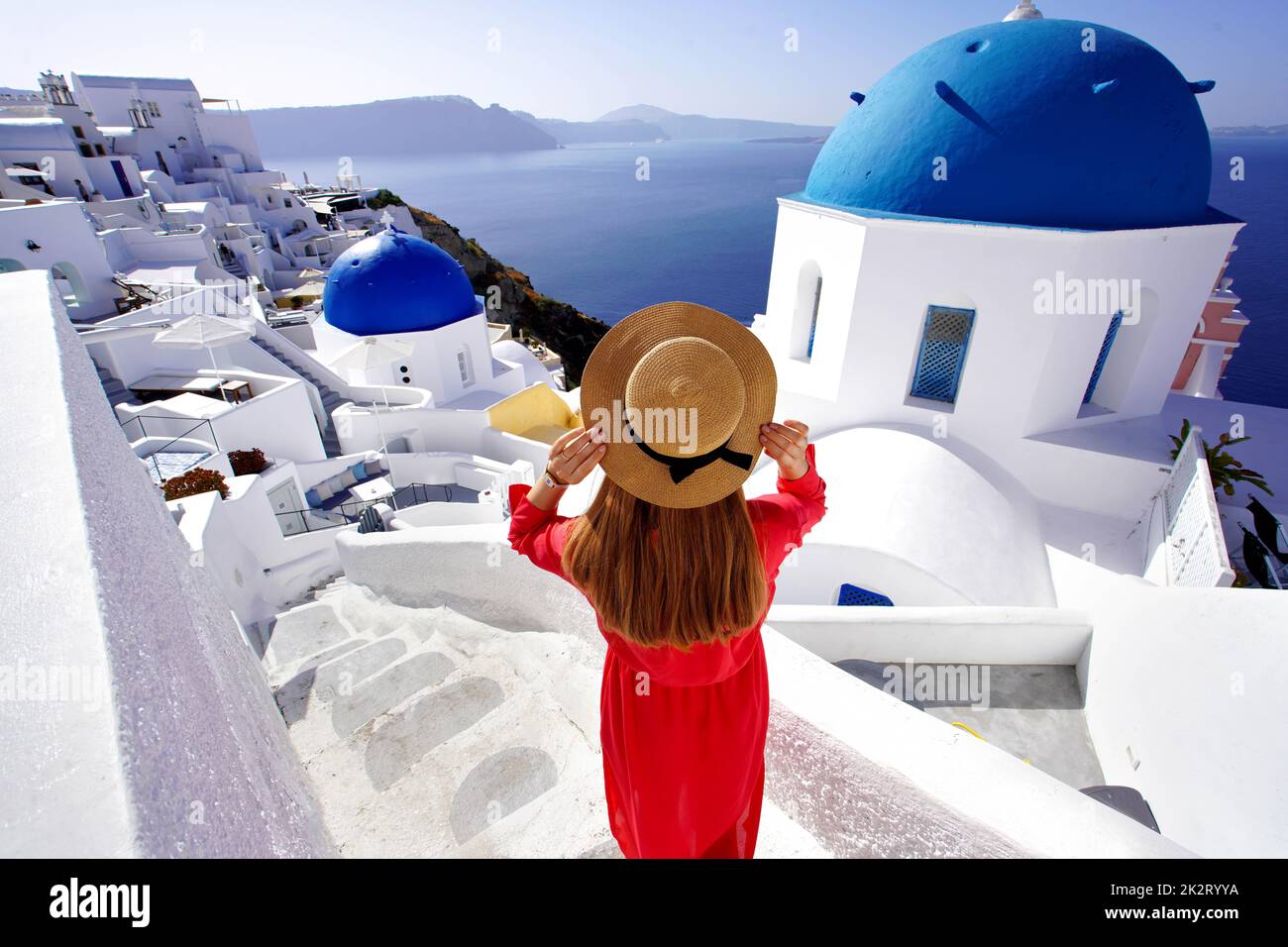 Holidays in Greece. Traveler girl enjoying panoramic view of Santorini. Wide angle. Stock Photo